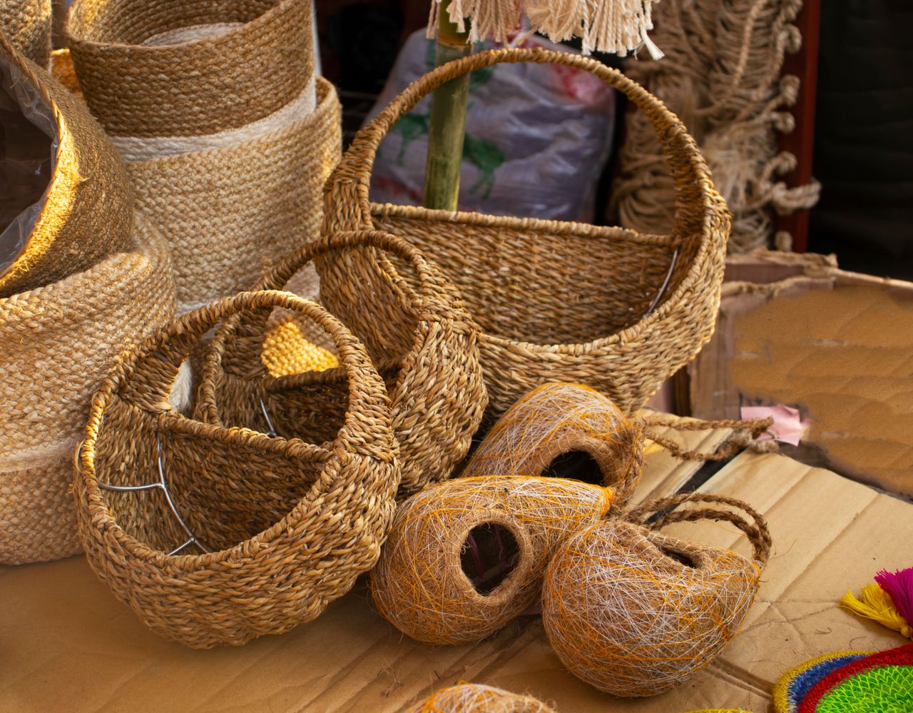 services-02 Artisanal woven baskets and handcrafted bird nests for sale at a cultural market.